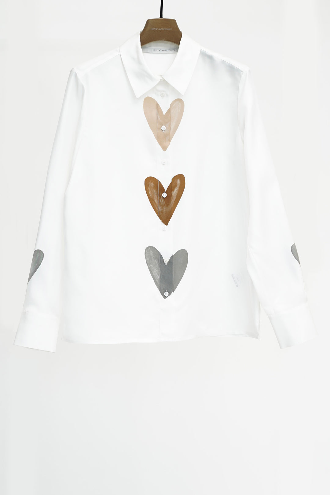 White shirt with heart-shaped buttons on a white background