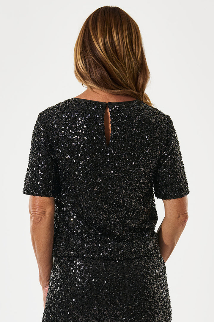 Black sequin dress worn by a person on a white background