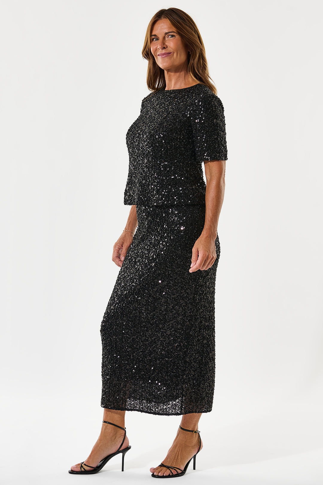 Woman wearing a black sequin dress on a white background