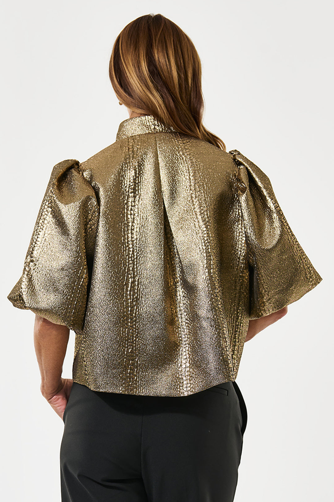 Gold metallic jacket worn by a person on a white background