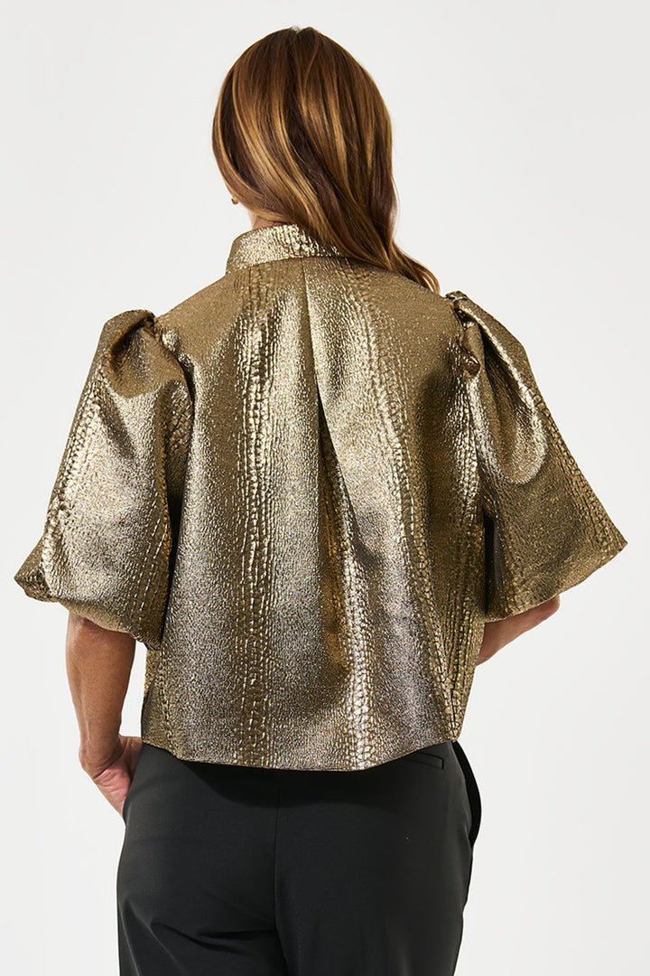 Gold metallic jacket worn by a person on a white background
