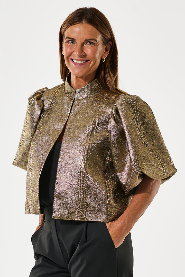 Woman wearing a metallic gold jacket on a white background
