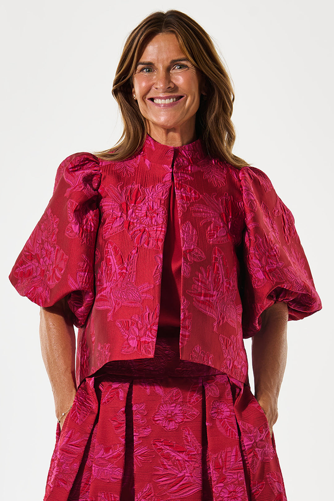 Woman wearing a pink patterned outfit on a white background