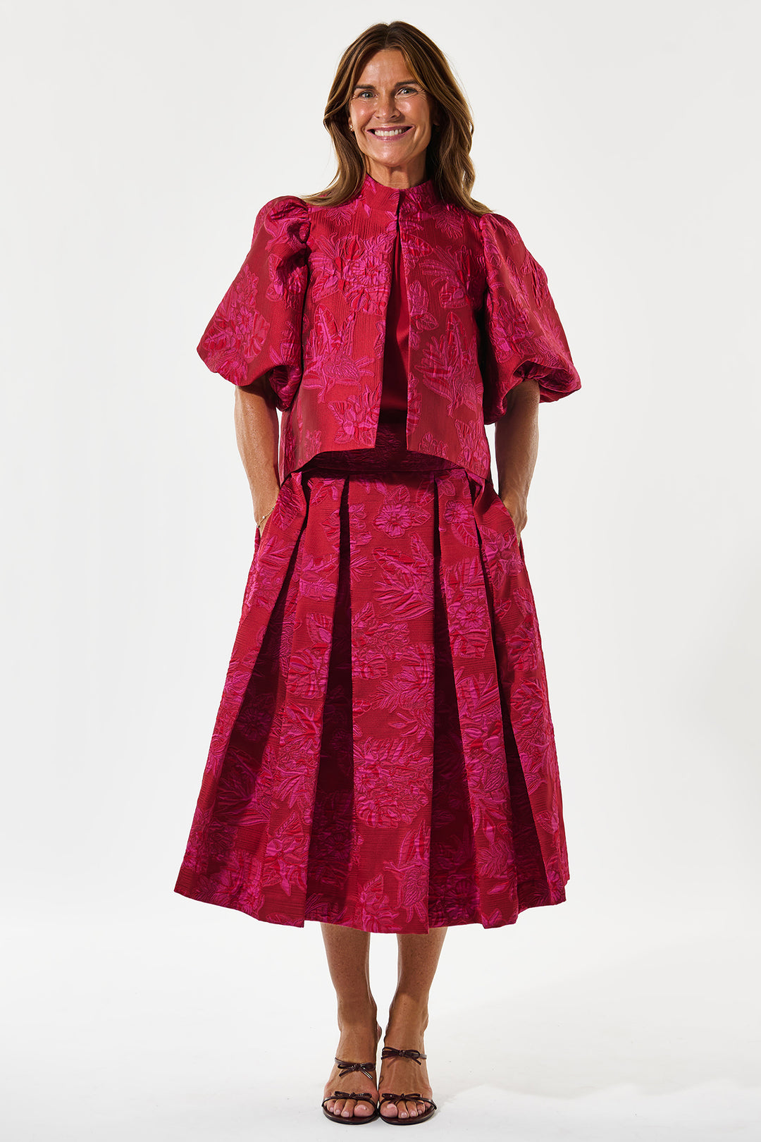 Woman wearing a pink patterned outfit on a white background