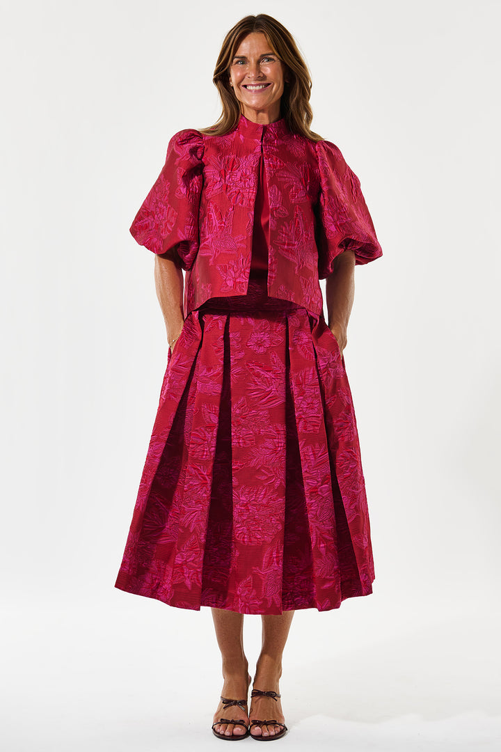 Woman wearing a pink patterned outfit on a white background