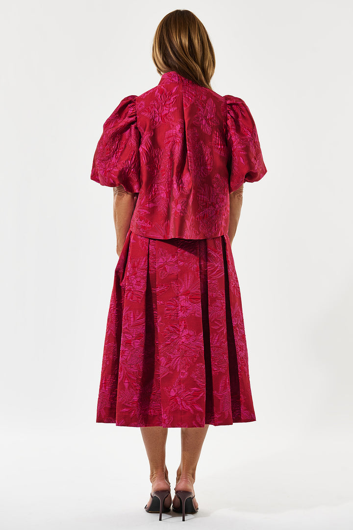 Person wearing a red dress with puff sleeves on a white background