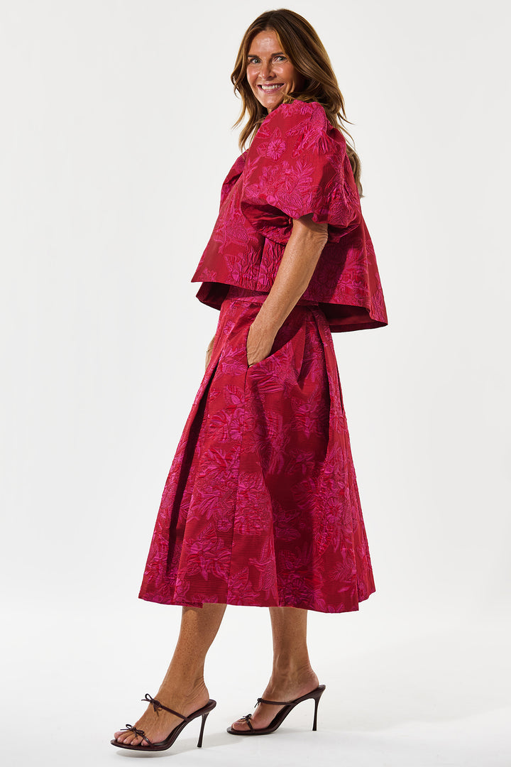 Woman wearing a pink patterned outfit on a white background