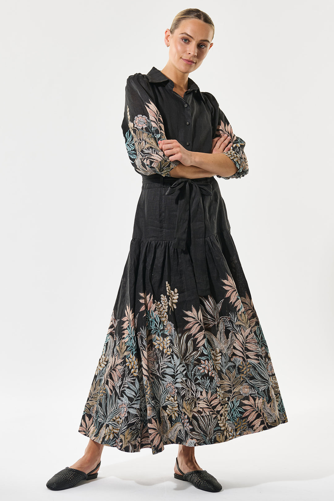Woman wearing a black dress with floral patterns on a white background