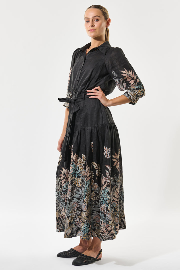 Woman wearing a black dress with floral patterns on a white background