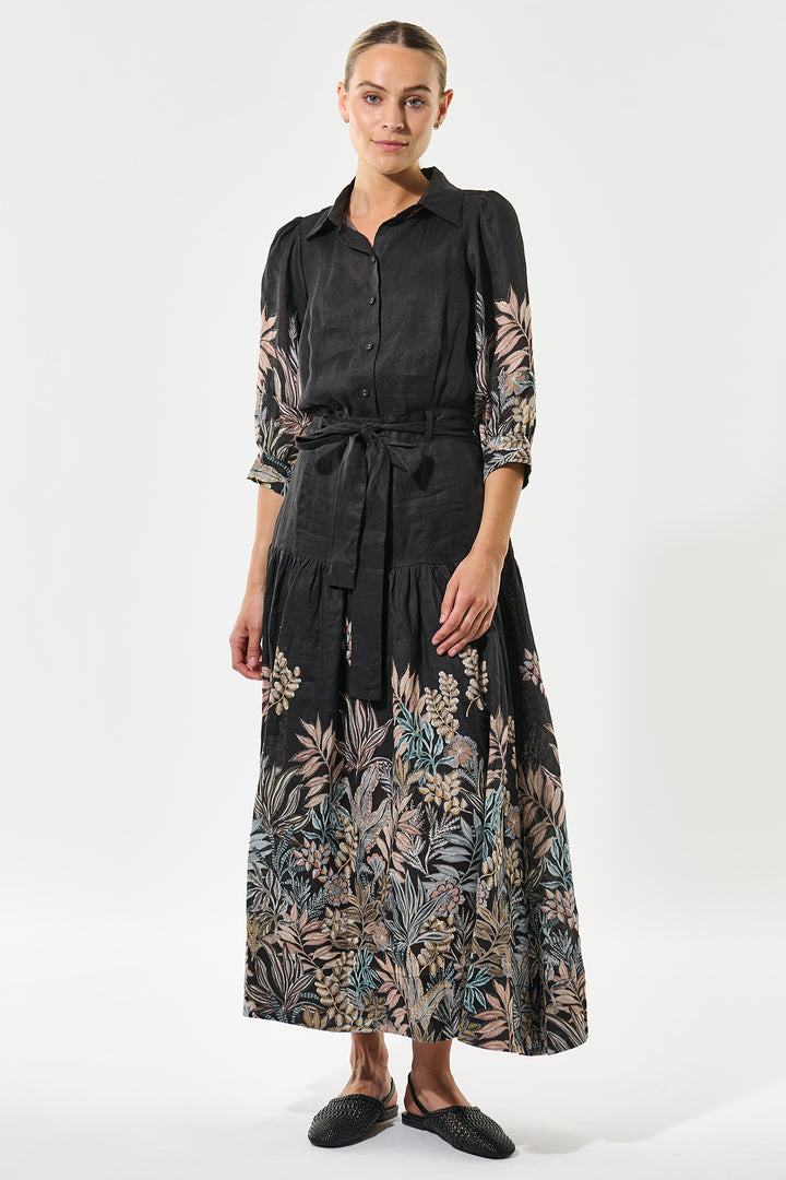 Woman wearing a black dress with floral patterns on a white background