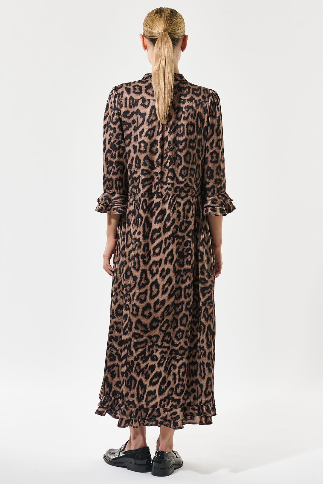 Person wearing a leopard print dress on a white background