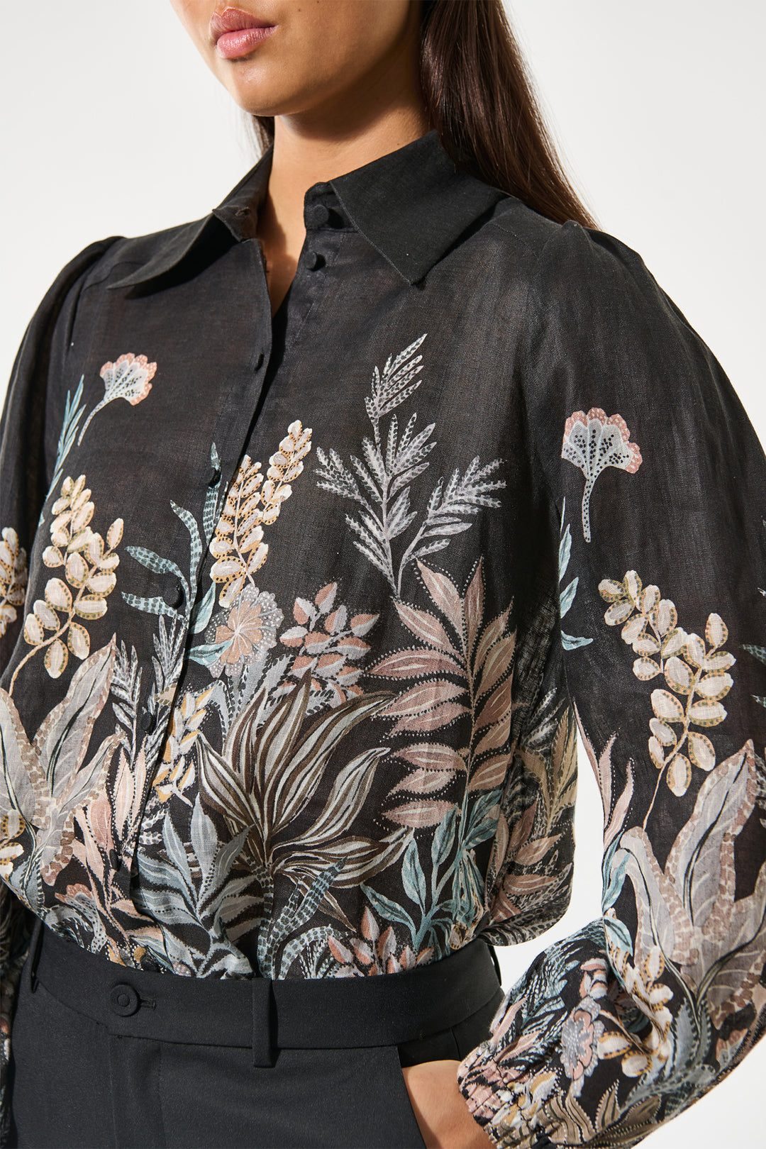 Black floral embroidered shirt worn by a person on a white background