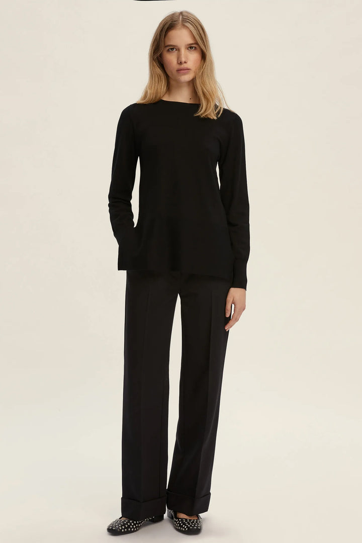 Woman wearing a black outfit on a plain background