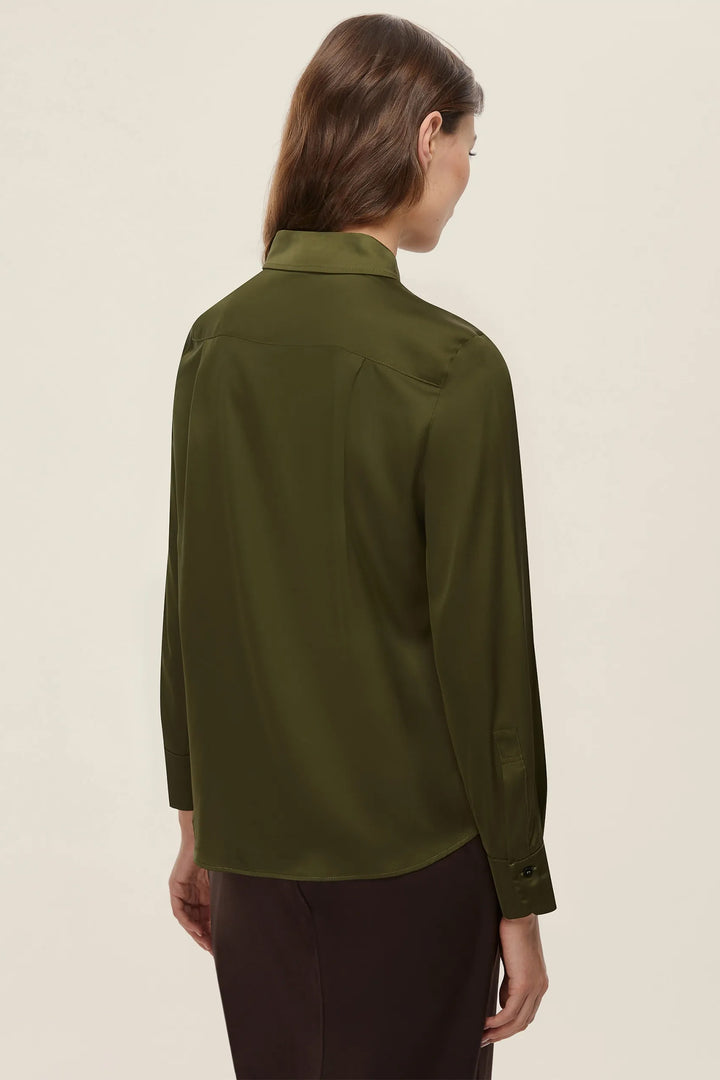 Person wearing a green shirt on a beige background