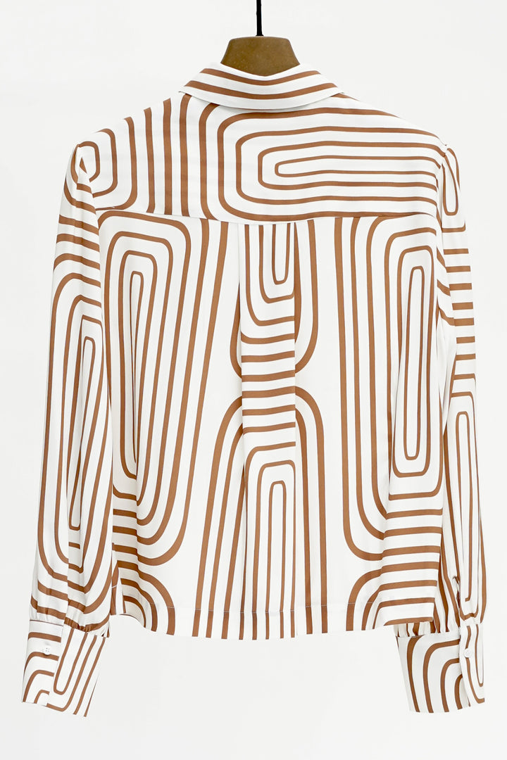 Mannequin wearing a shirt with brown abstract pattern on a white background