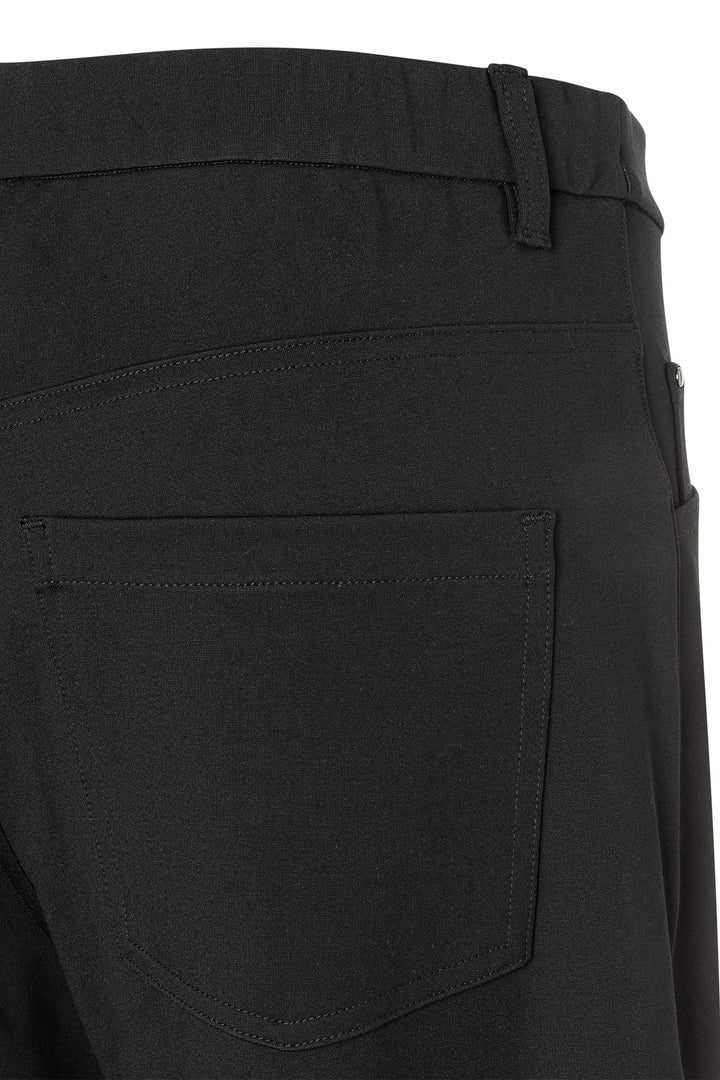 Close-up of black pants with a pocket and waistband detail.