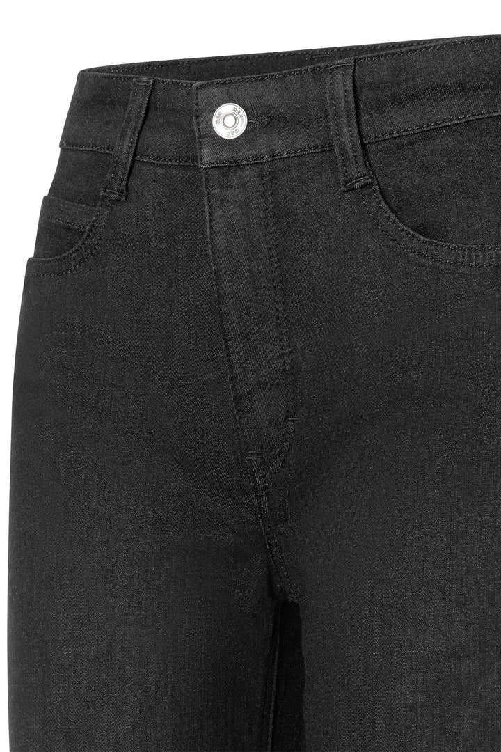 Close-up of black jeans with a button on a white background