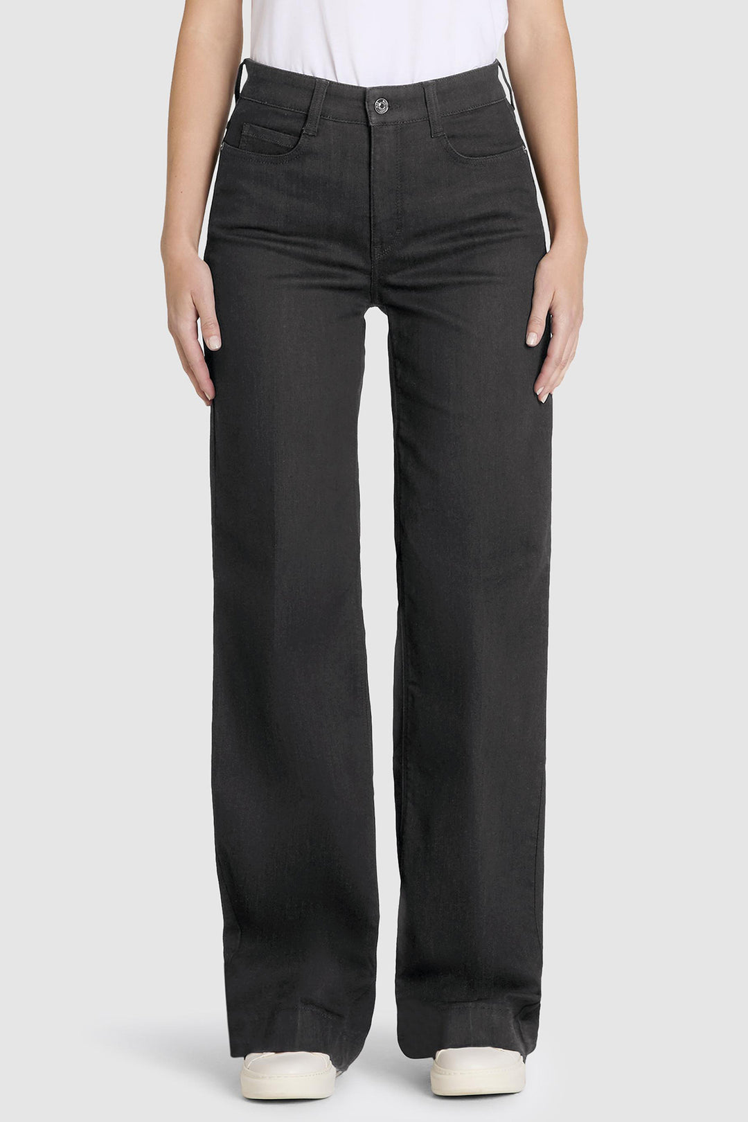 Person wearing black jeans on a white background