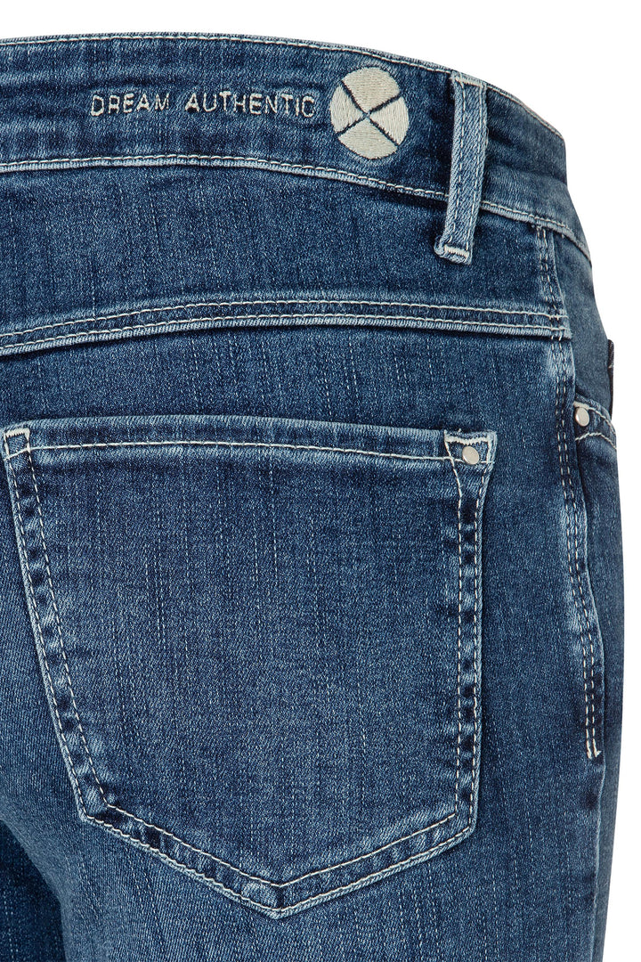 Close-up of blue jeans with 'Dream Authentic' branding on a white background