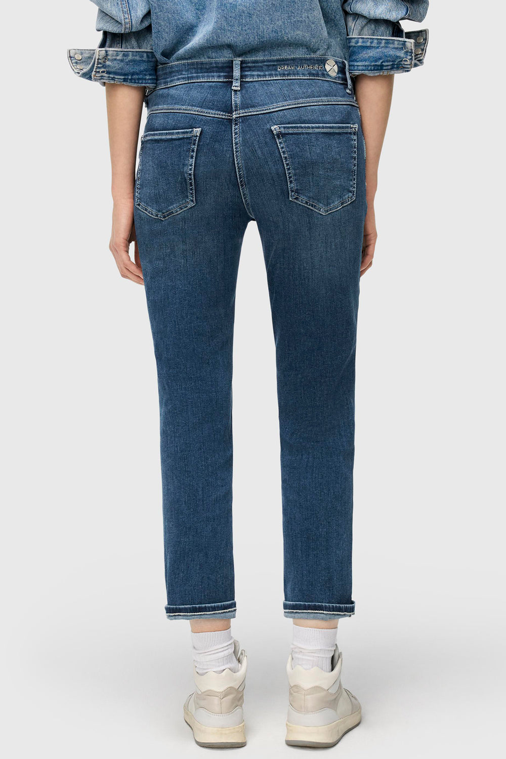 Person wearing blue jeans on a white background