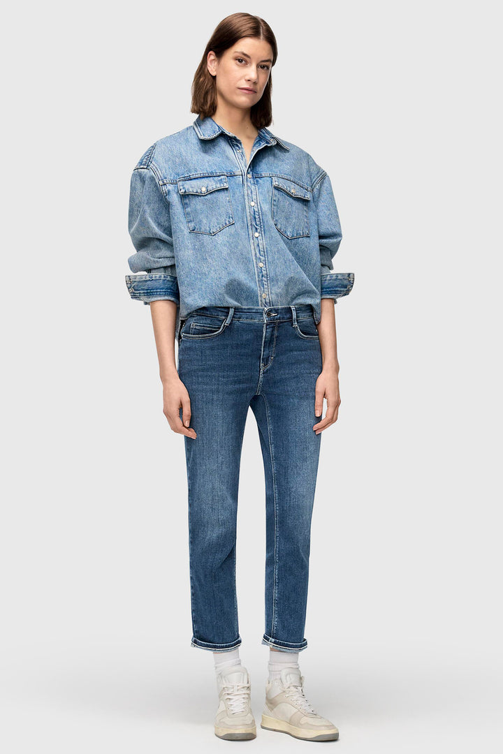 Person wearing a denim jacket and jeans on a white background