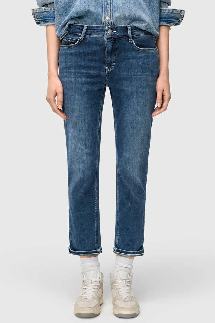 Person wearing blue jeans and a denim shirt on a white background