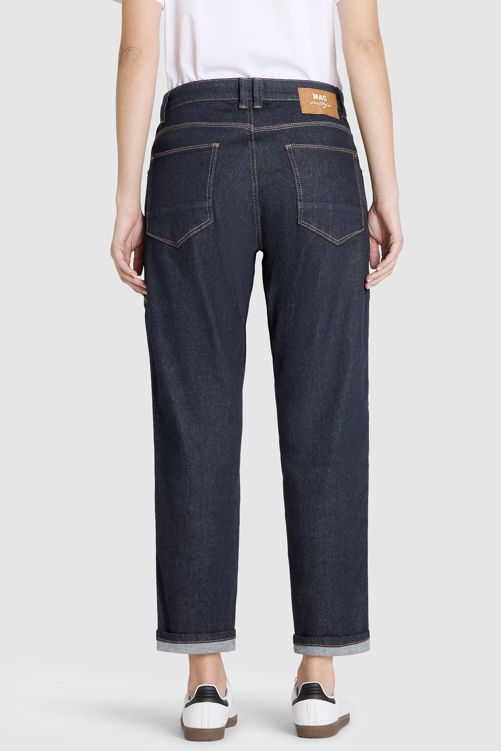 Person wearing dark blue jeans on a white background