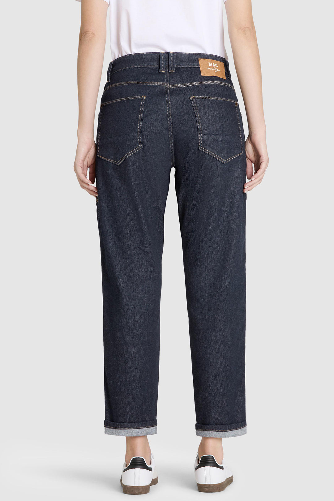 Person wearing dark blue jeans on a white background