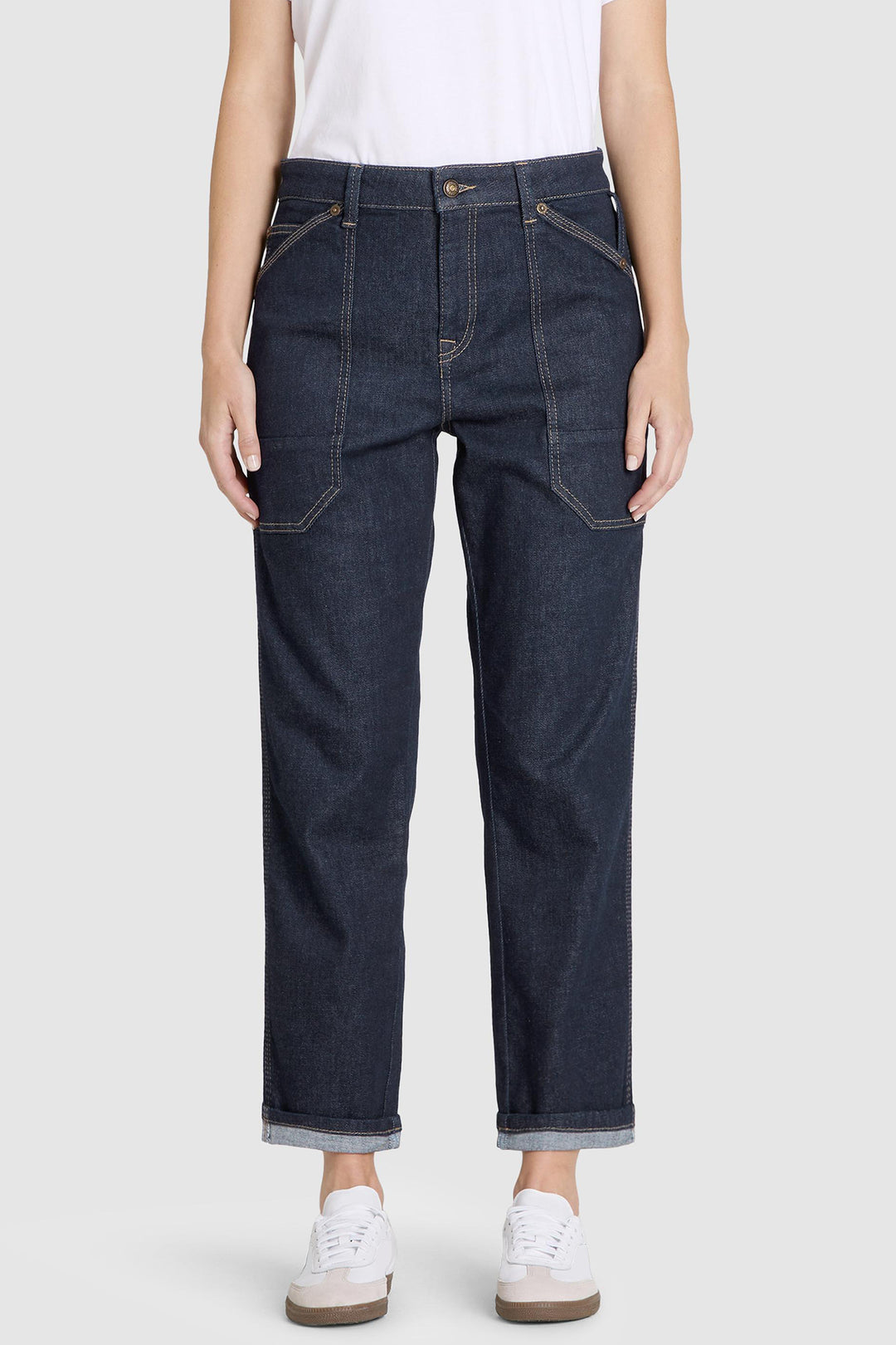 Dark blue jeans worn by a person on a white background