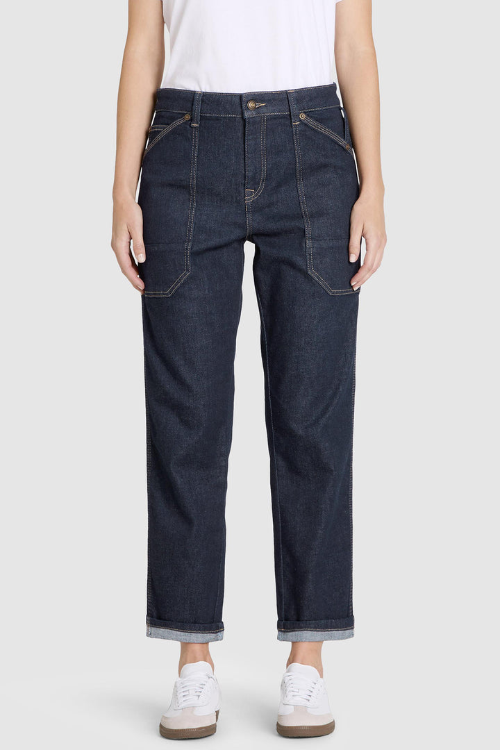 Dark blue jeans worn by a person on a white background