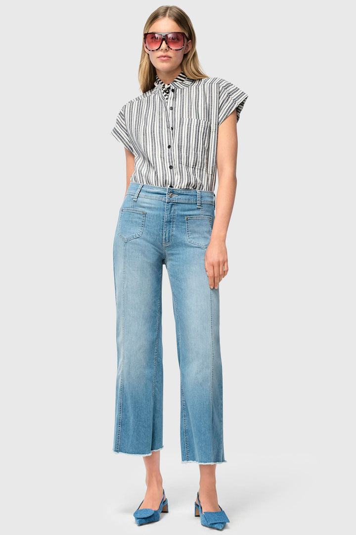 Woman wearing a striped shirt and blue jeans on a white background