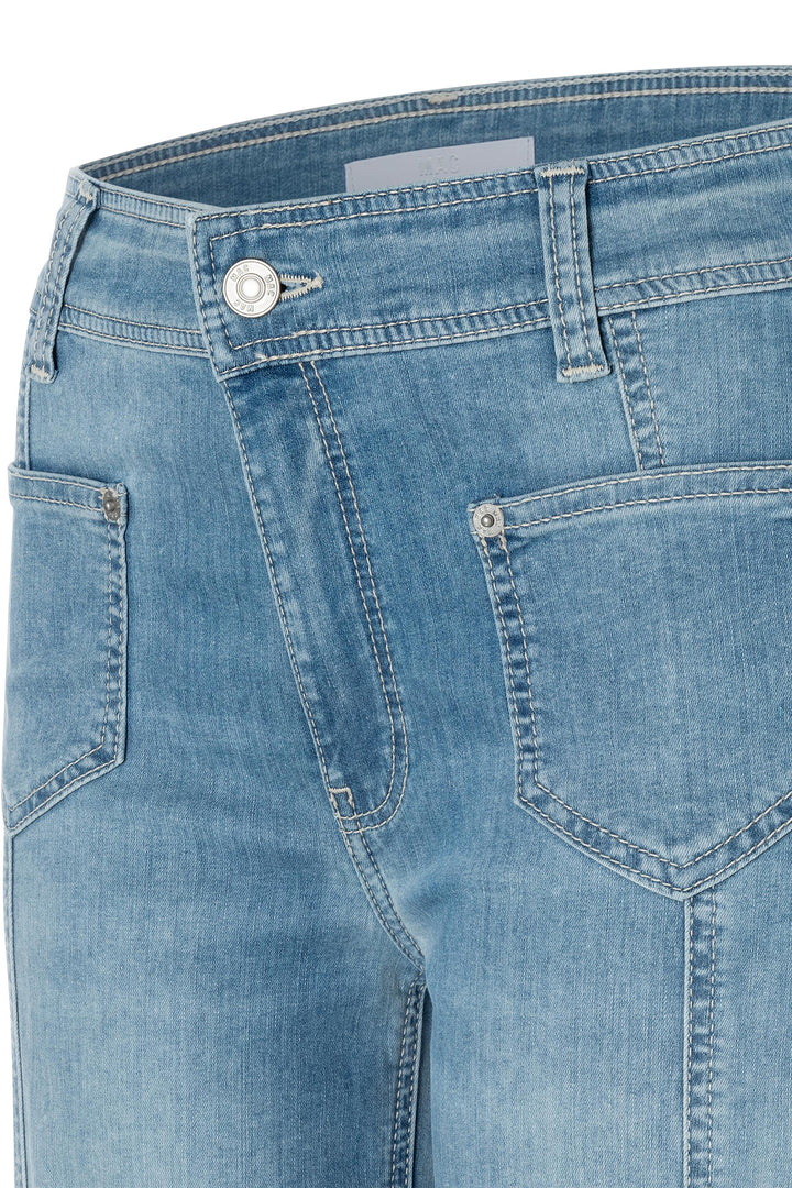 Close-up of blue denim jeans with a button and zipper detail on a white background