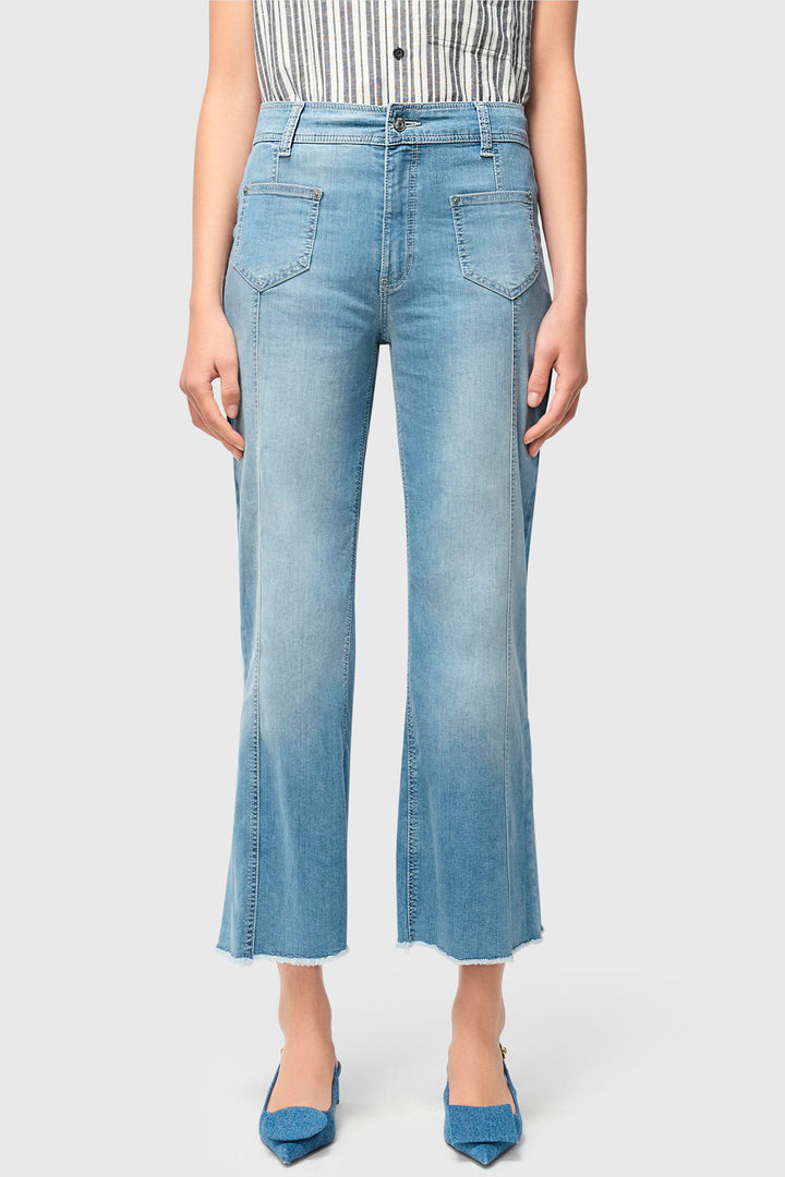 Person wearing light blue jeans on a plain background