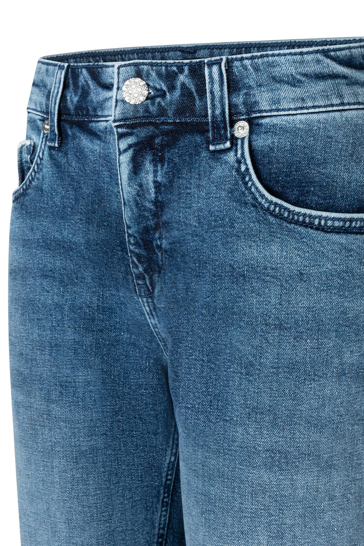 Close-up of blue jeans with a focus on the waistband and pocket area.