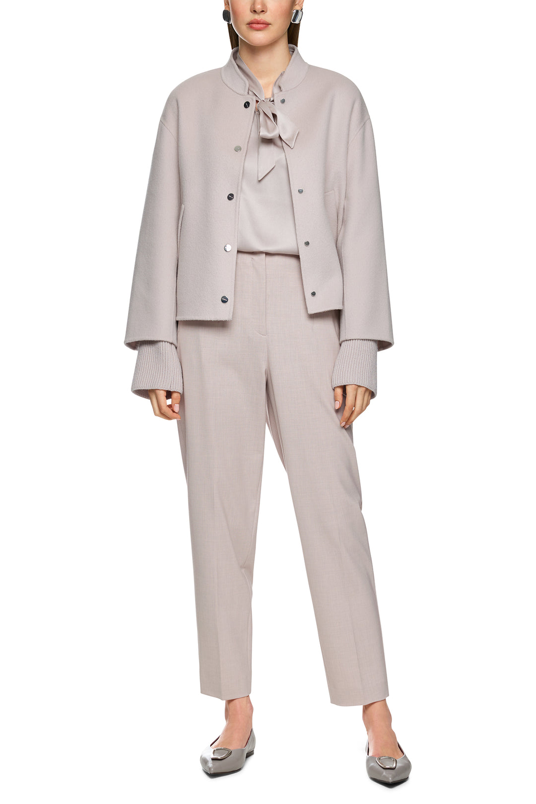 Woman wearing a light gray suit with a blouse on a white background