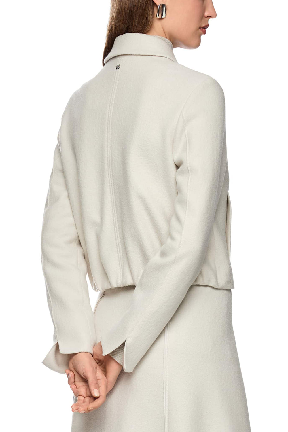 Person wearing a light gray coat on a white background