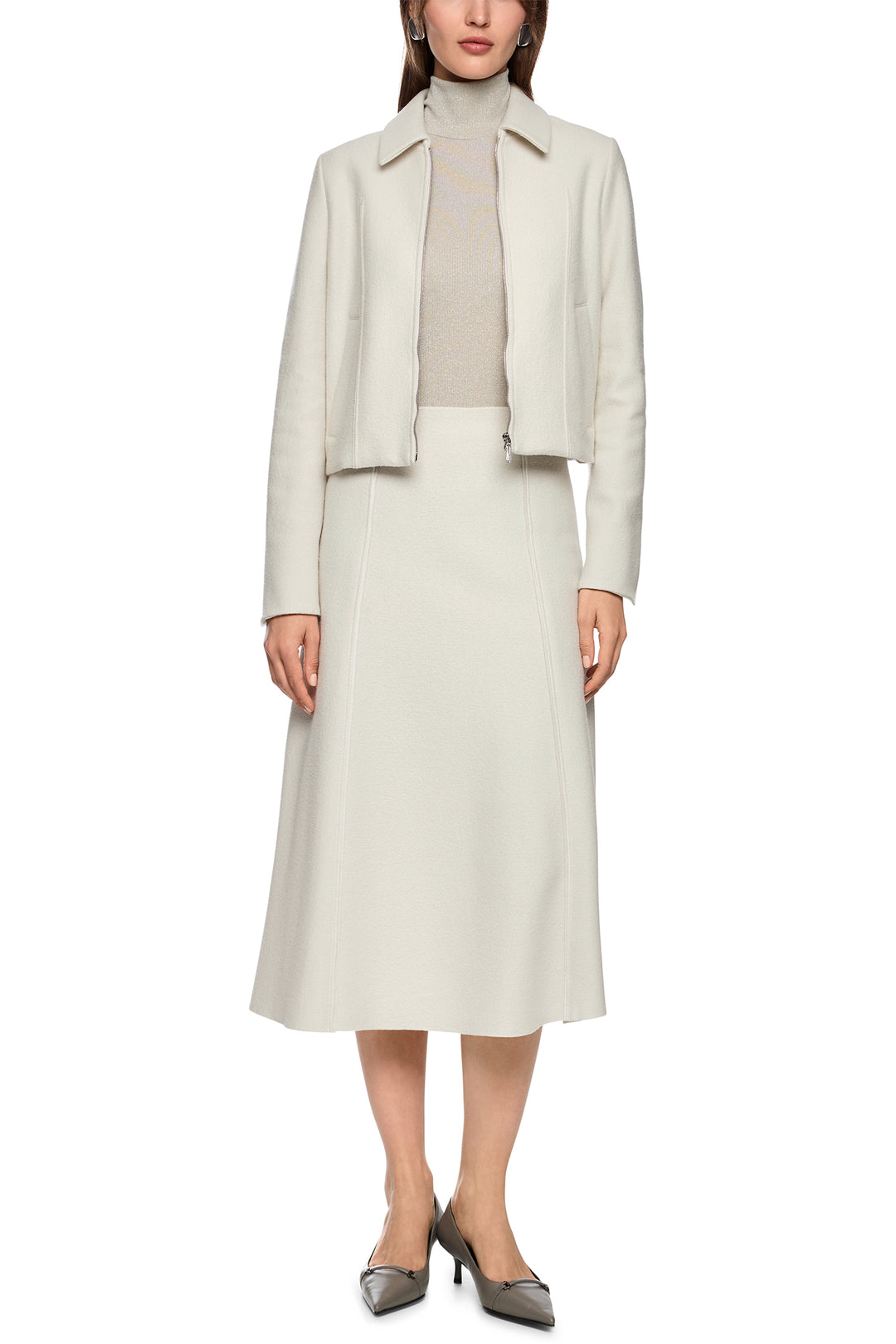 Woman wearing a light gray suit with a jacket and skirt on a white background