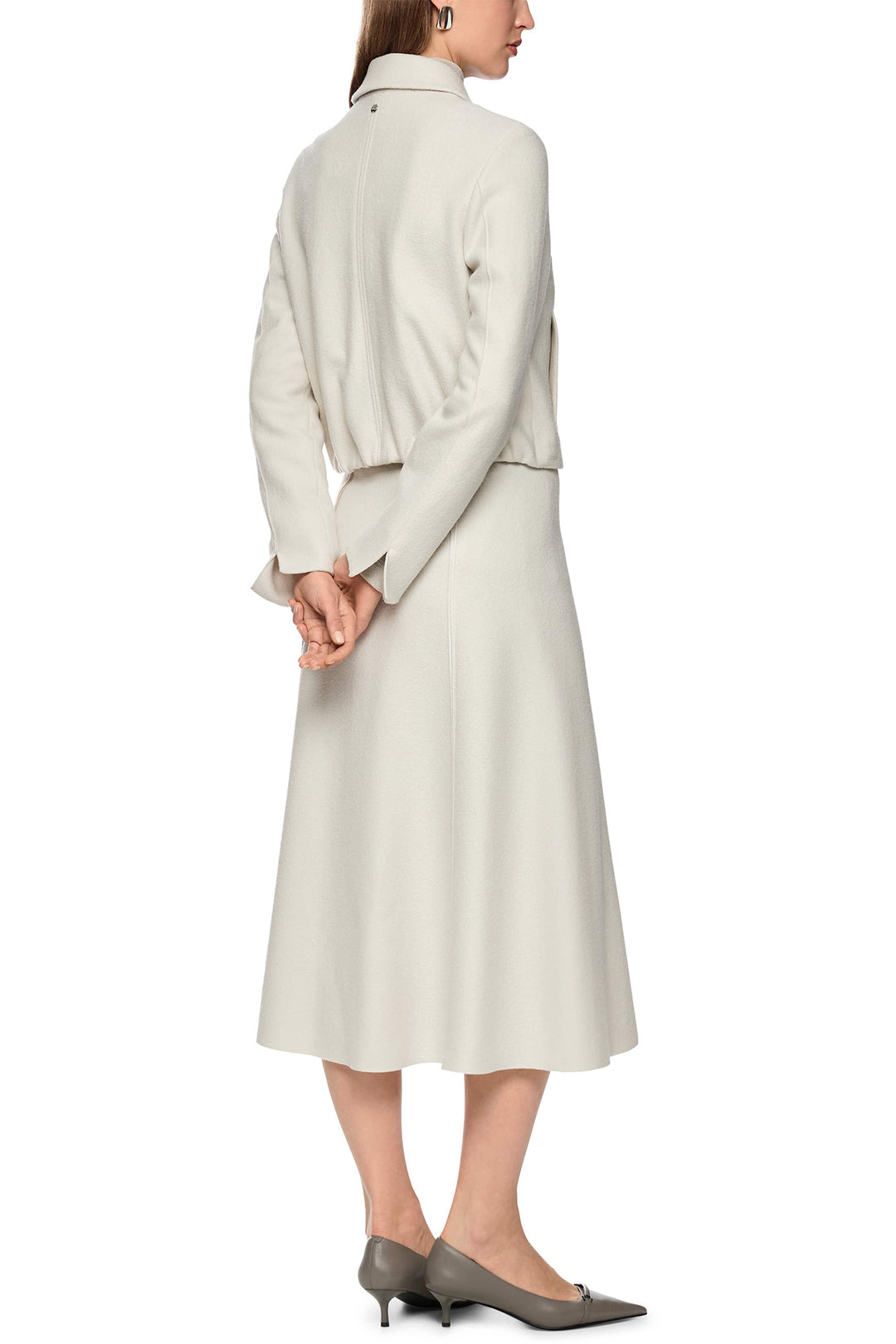 Woman wearing a light gray suit on a white background