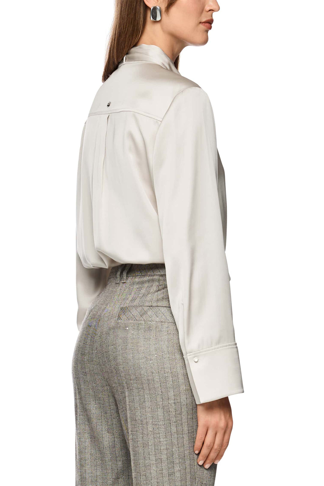 Woman wearing a white blouse and gray checkered pants on a white background