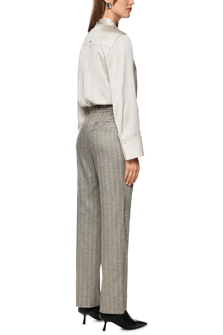 Woman wearing a white blouse and gray checkered pants on a white background