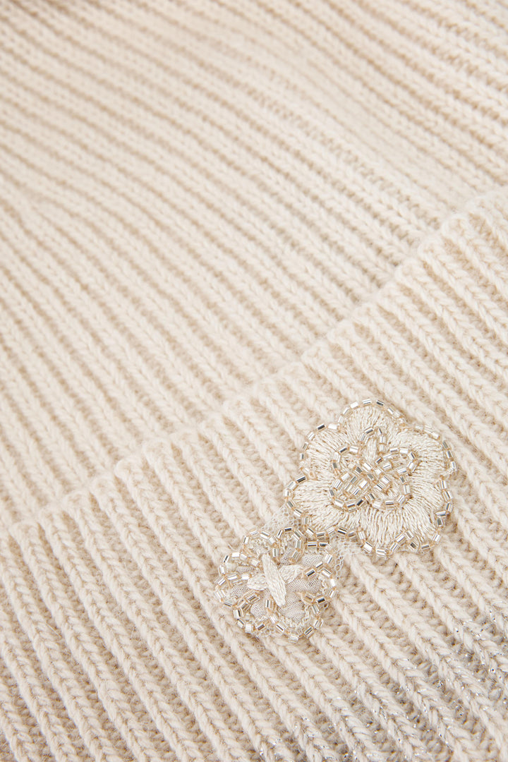 Silver ring with floral design on a beige textured fabric background