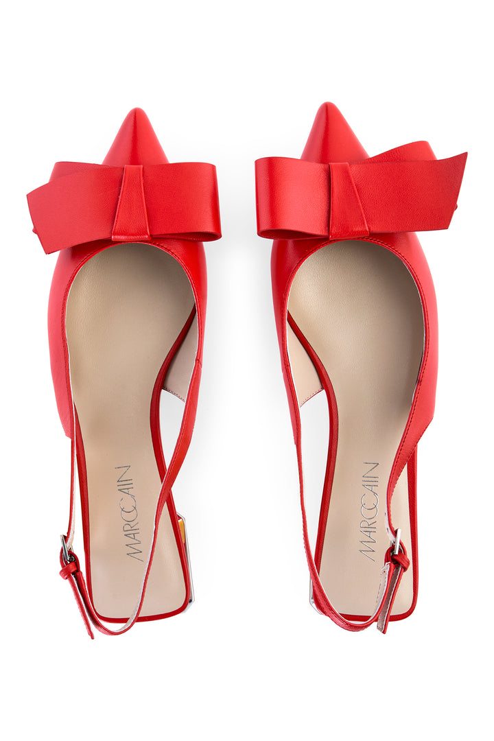 Red high-heeled shoes with large bows on a white background