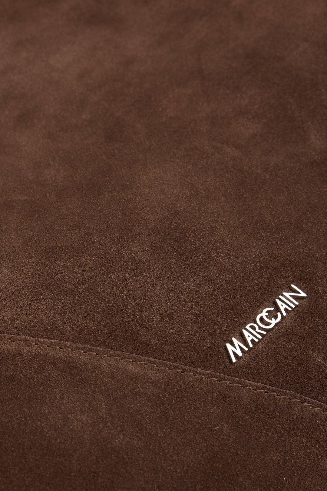 Brown textured fabric with 'Marc Cain' branding