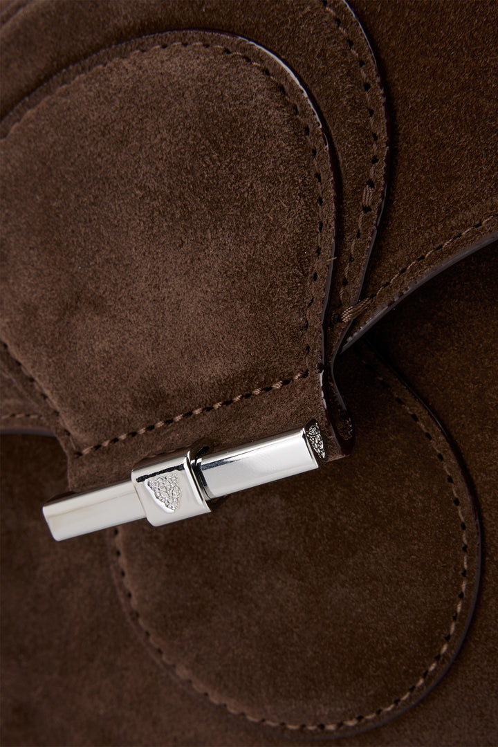 Close-up of a brown leather product with a silver clasp