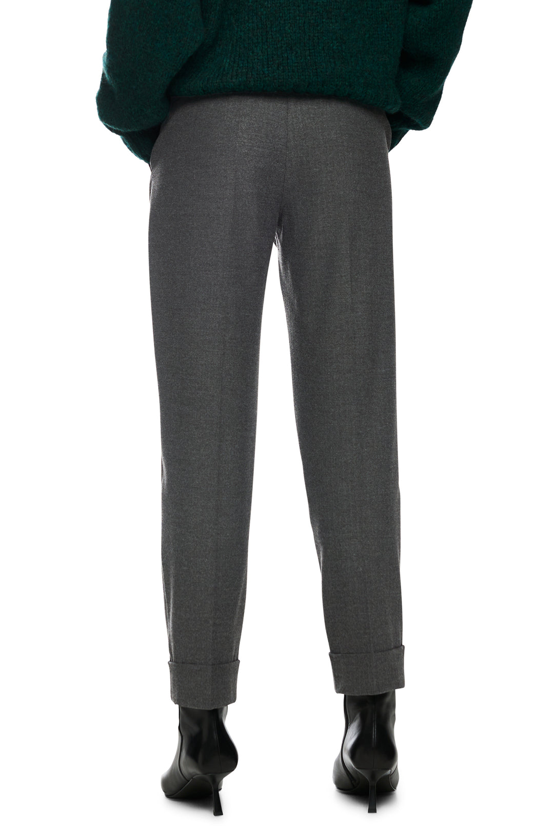 Gray pants worn with a dark green sweater on a white background