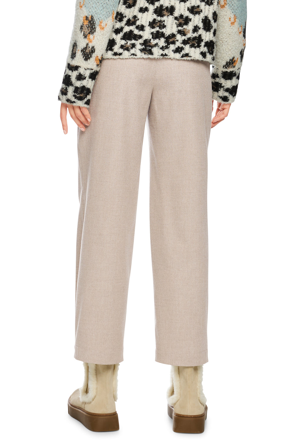 Beige pants worn by a person on a white background