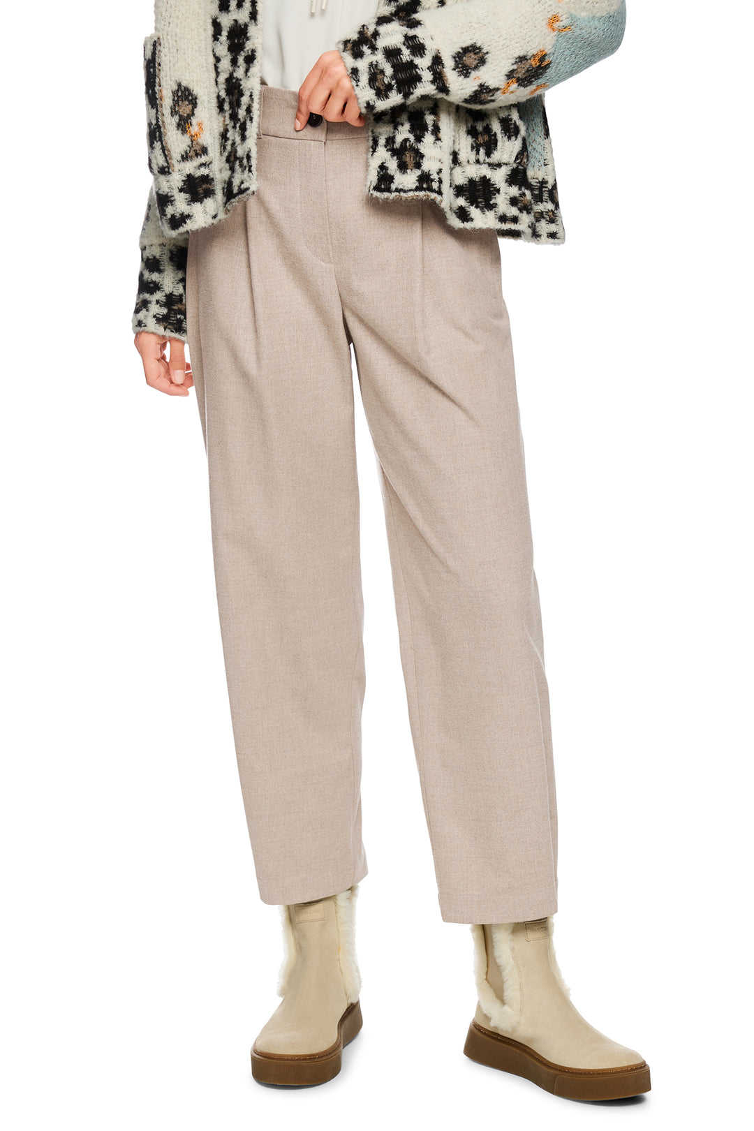 Person wearing beige pants and a patterned sweater on a white background