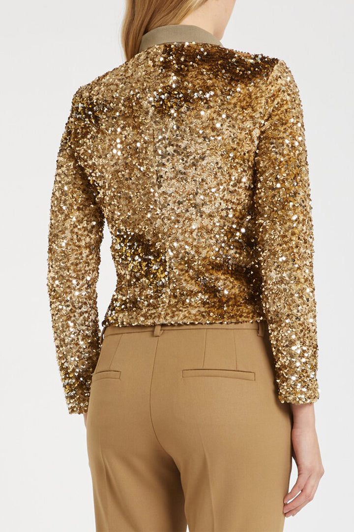Gold sequin jacket worn by a person on a white background