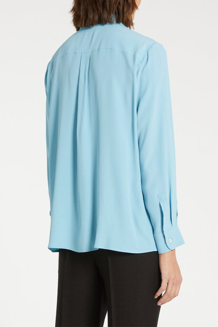Light blue blouse worn by a person on a white background