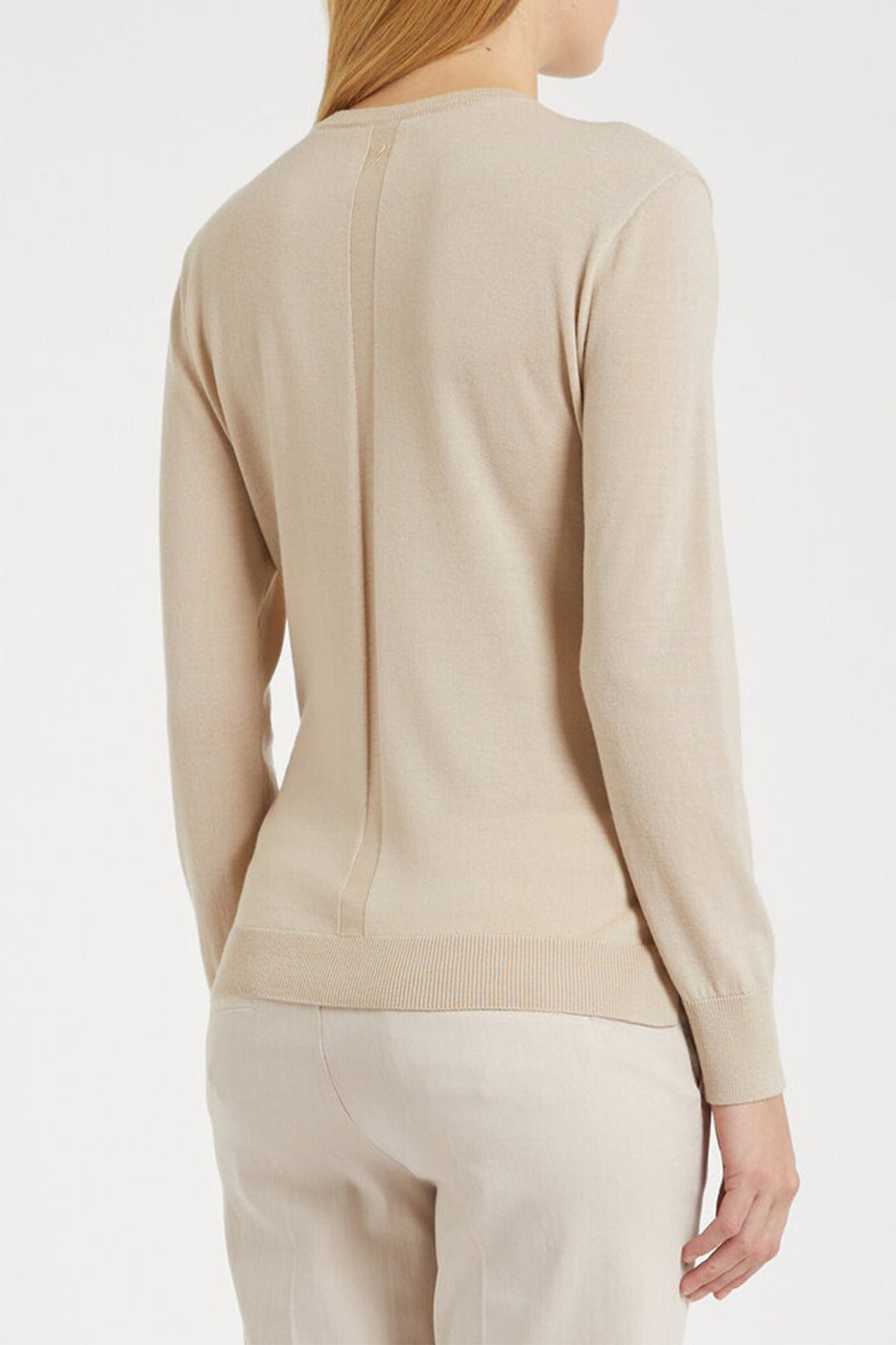 Beige sweater worn by a person on a white background